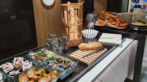 Un área de bufé con diversas opciones de comida, como pasteles, frutas y salsas.