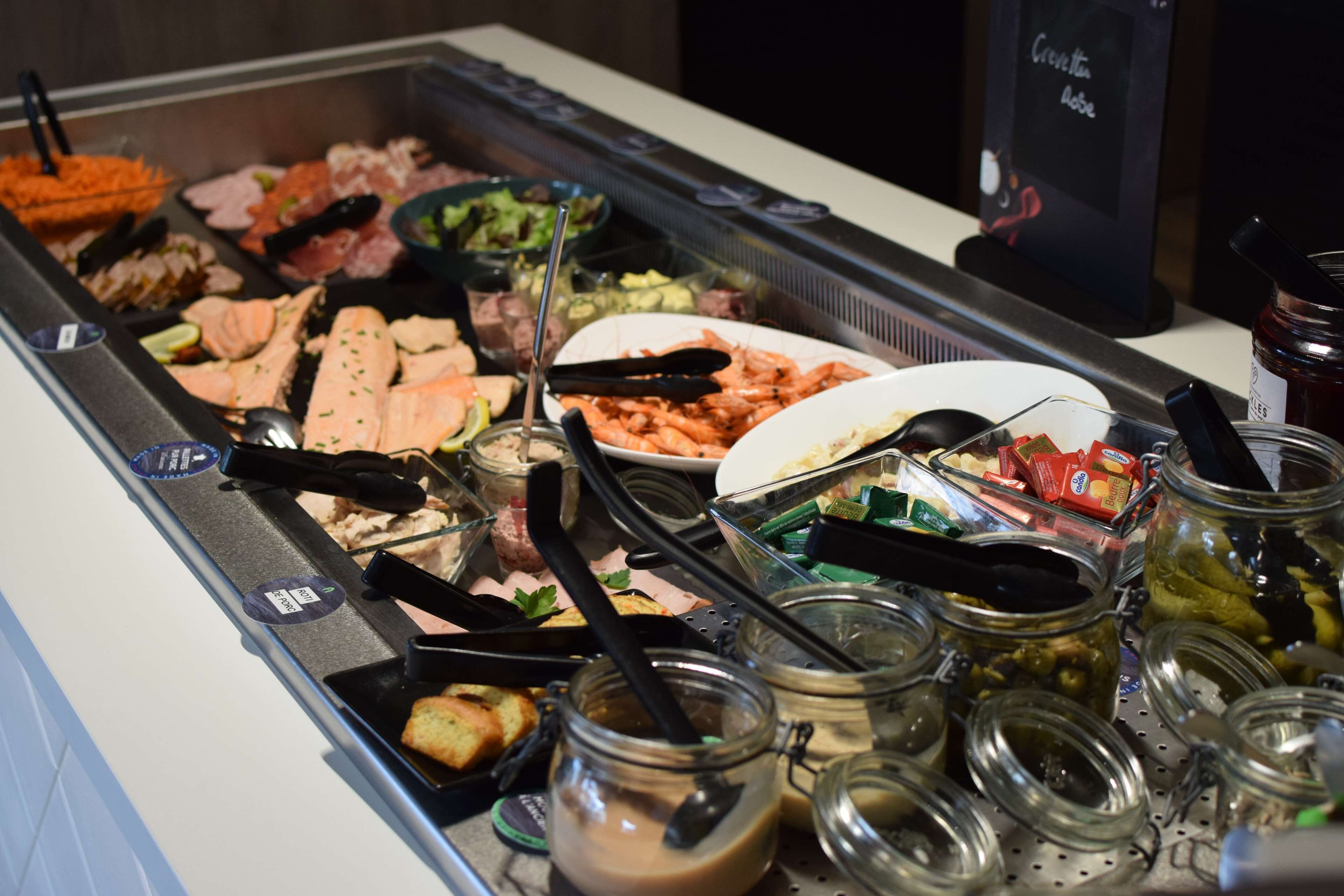 A buffet with various food items and condiments.