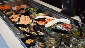 A buffet with various food items and condiments.