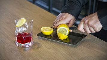 A person slicing a lemon on a wooden table.