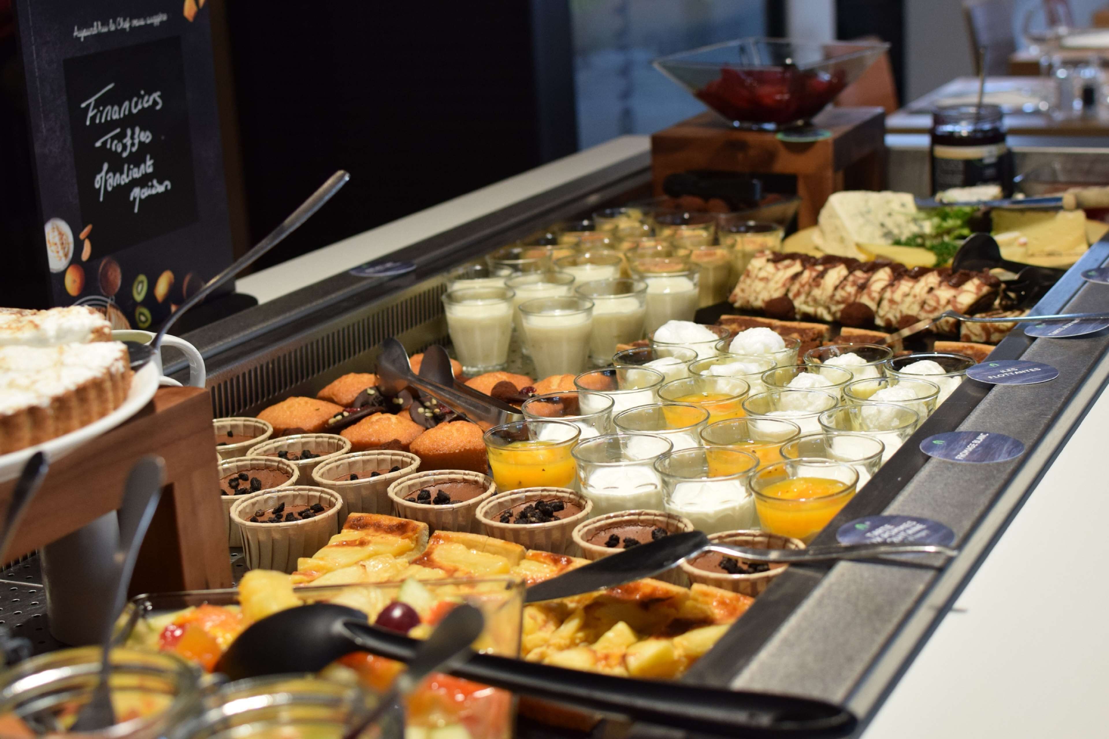 Een buffet met diverse gerechten, waaronder gebak, fruit en drankjes.