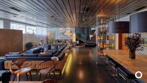 Un área de bar moderna con asientos de cuero, una barra de madera y una variedad de botellas de licores.