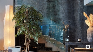 A modern interior with a staircase, a large potted plant, and a decorative vase. - Þingholt by Center Hotels (Reykjavik)