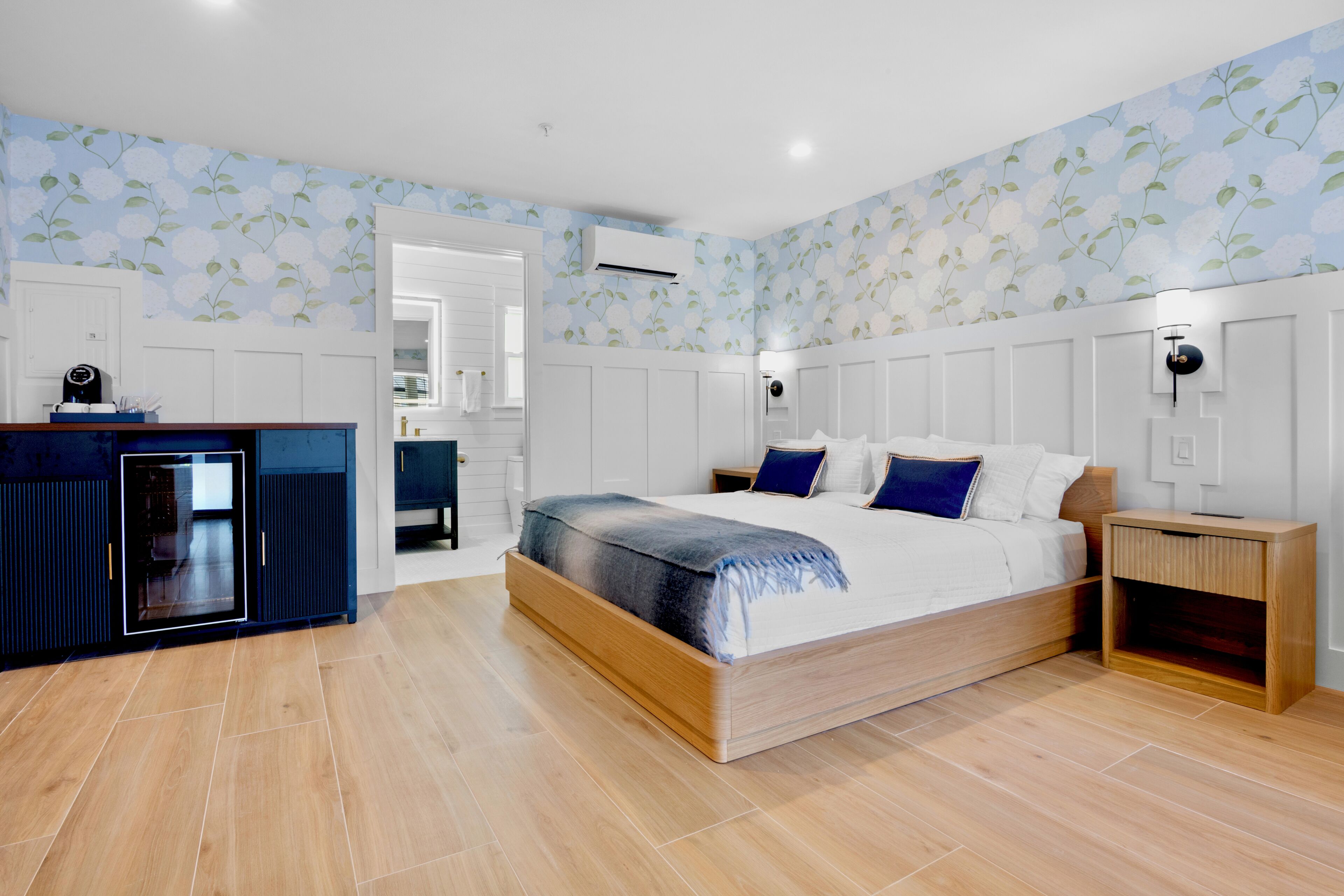 A bedroom with a bed, bedside tables, a wardrobe, and a built-in desk with a chair.