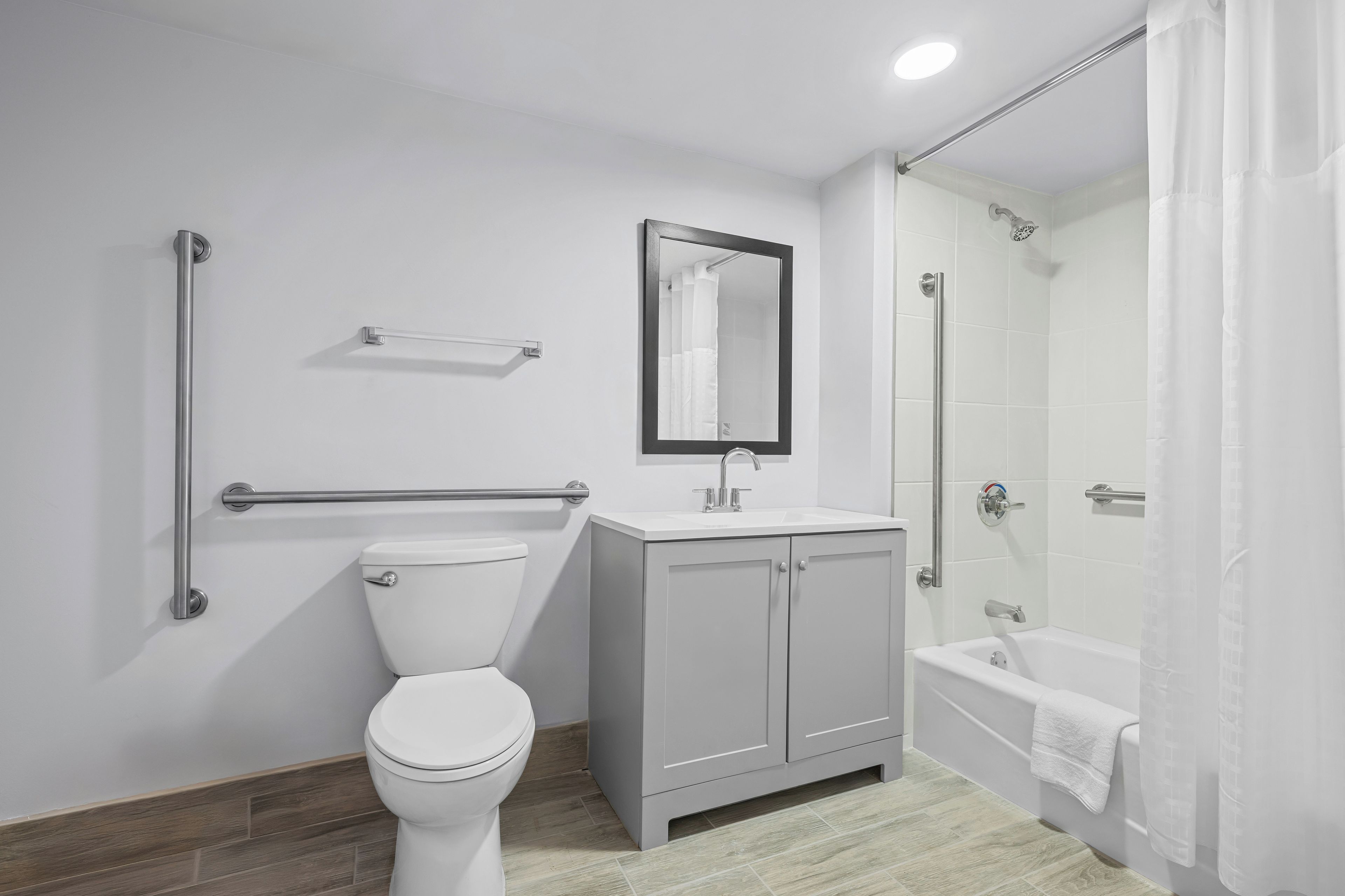 Un baño con inodoro, lavabo, espejo y ducha.