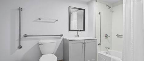 Un baño con inodoro, lavabo, espejo y ducha.