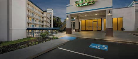 A hotel entrance with a sign reading 'Home Towne Studios by Red Reef.'