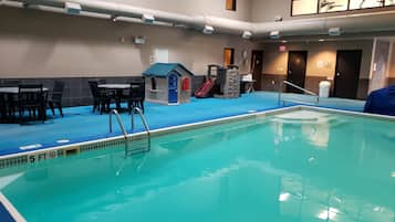 Swimmers can enjoy the pool with two ladders for easy access, a depth indicator, and a seating area nearby.