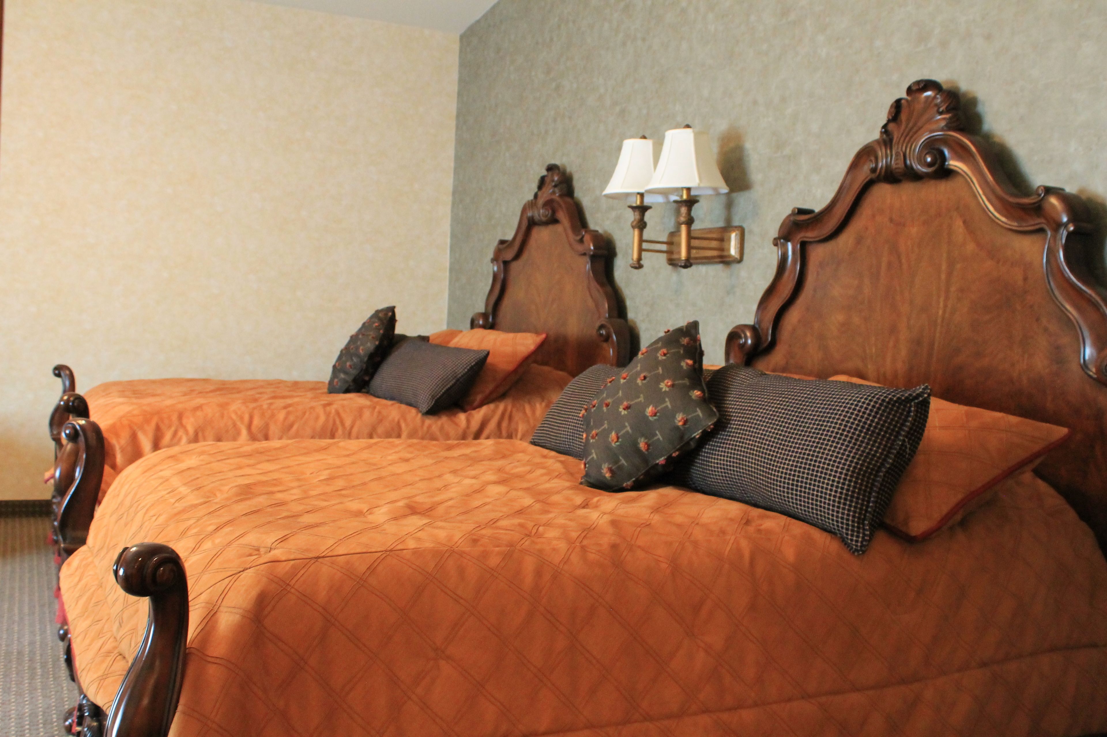 A double bed with a wooden headboard and two bedside lamps.