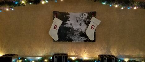 Un mur orné d’un tableau encadré, deux décorations de Noël en forme de chaussettes portant des lettres, et trois grille-pain posés sur un comptoir.