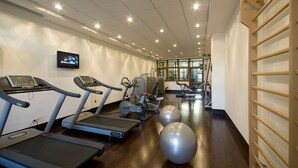 Una sala de gimnàstica amb cintes de córrer, el·líptiques i pilotes d'exercici.