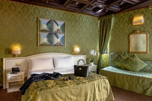 A hotel room with a large bed, a bedside table with a lamp, a nightstand with a phone, and a decorative mirror. - Residenza Canova Tadolini (Rome)