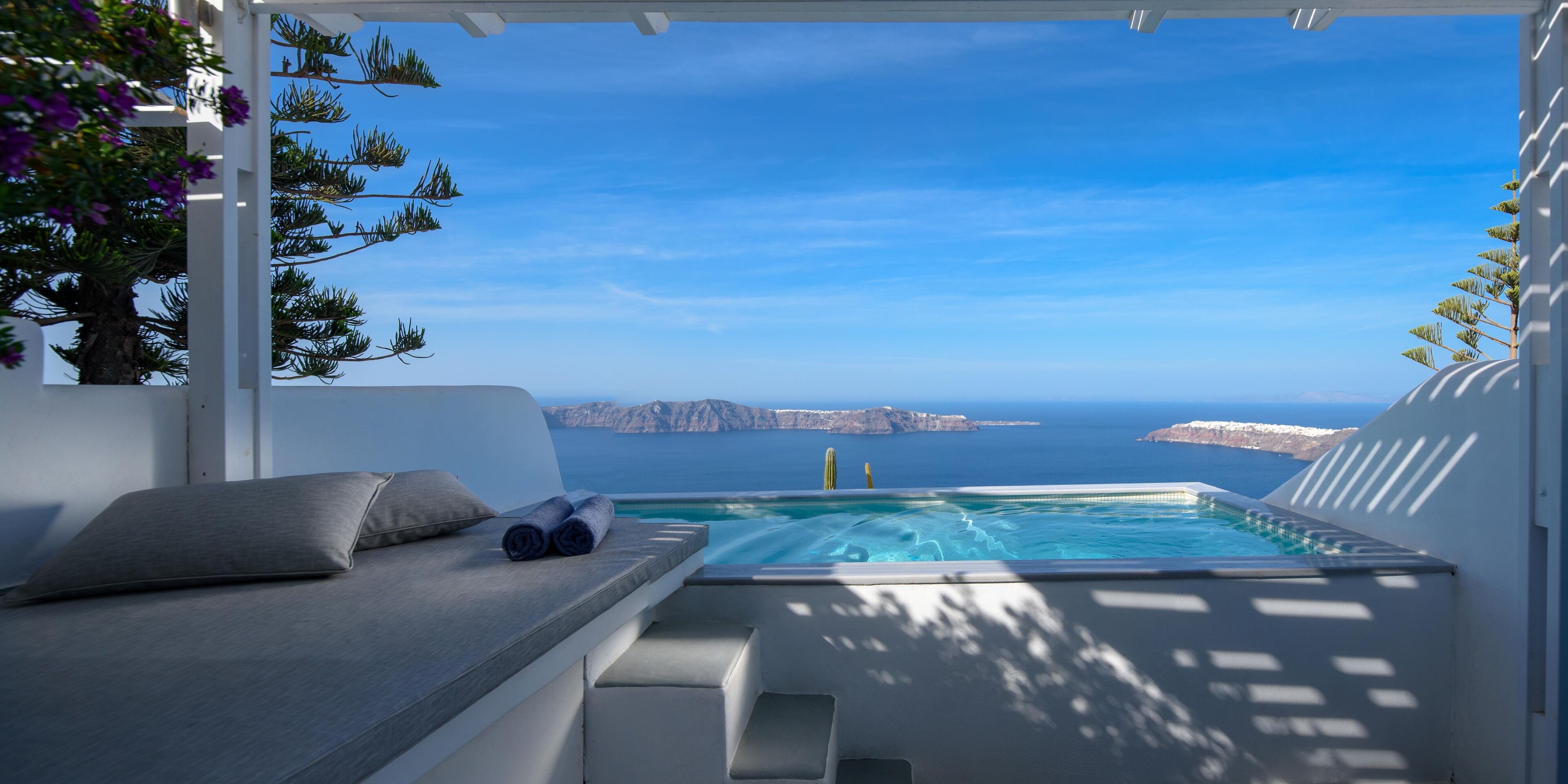 Un espacio al aire libre con sol, vistas al mar y una isla distante.