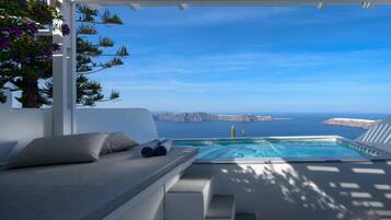 Un espacio al aire libre con sol, vistas al mar y una isla distante.