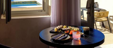 Ein Zimmer mit Meerblick, ein Tisch mit Speisen und Getränken sowie ein Stuhl.