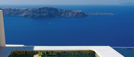 A pool with a clear view of the sea and a distant island.