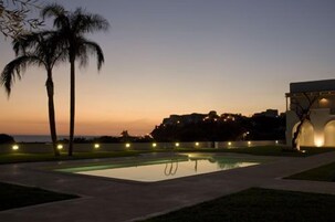 季节性开放的室外游泳池，池畔遮阳伞，日光浴躺椅