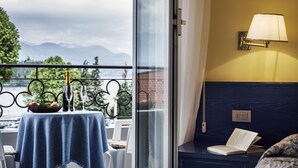 Un balcon avec une table dressée pour deux personnes, une bouteille de champagne et un livre.