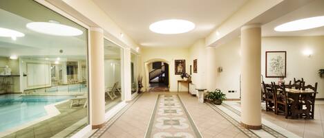 Un hall d’hôtel avec une piscine, un escalier et un espace repas.