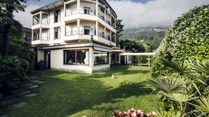 Un hôtel à plusieurs étages doté de balcons, d’une pelouse bien entretenue et d’une végétation luxuriante.