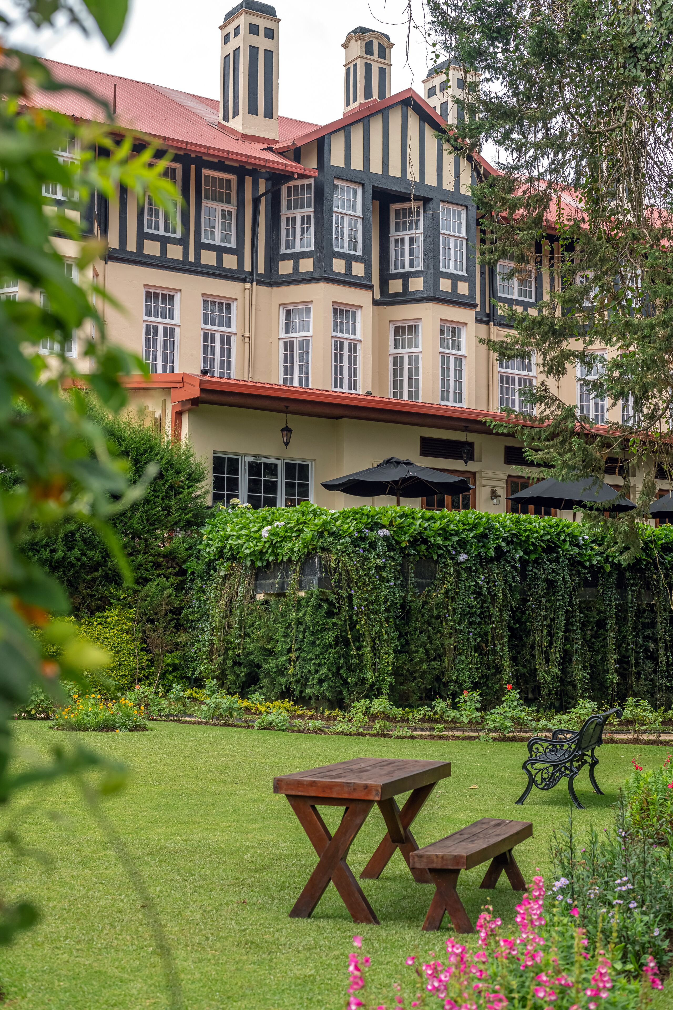 A traditional building with a garden, a picnic table, and a bench.