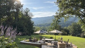 A patio with stone flooring, outdoor furniture, and umbrellas. - Andon-Reid Inn B&B (Waynesville)