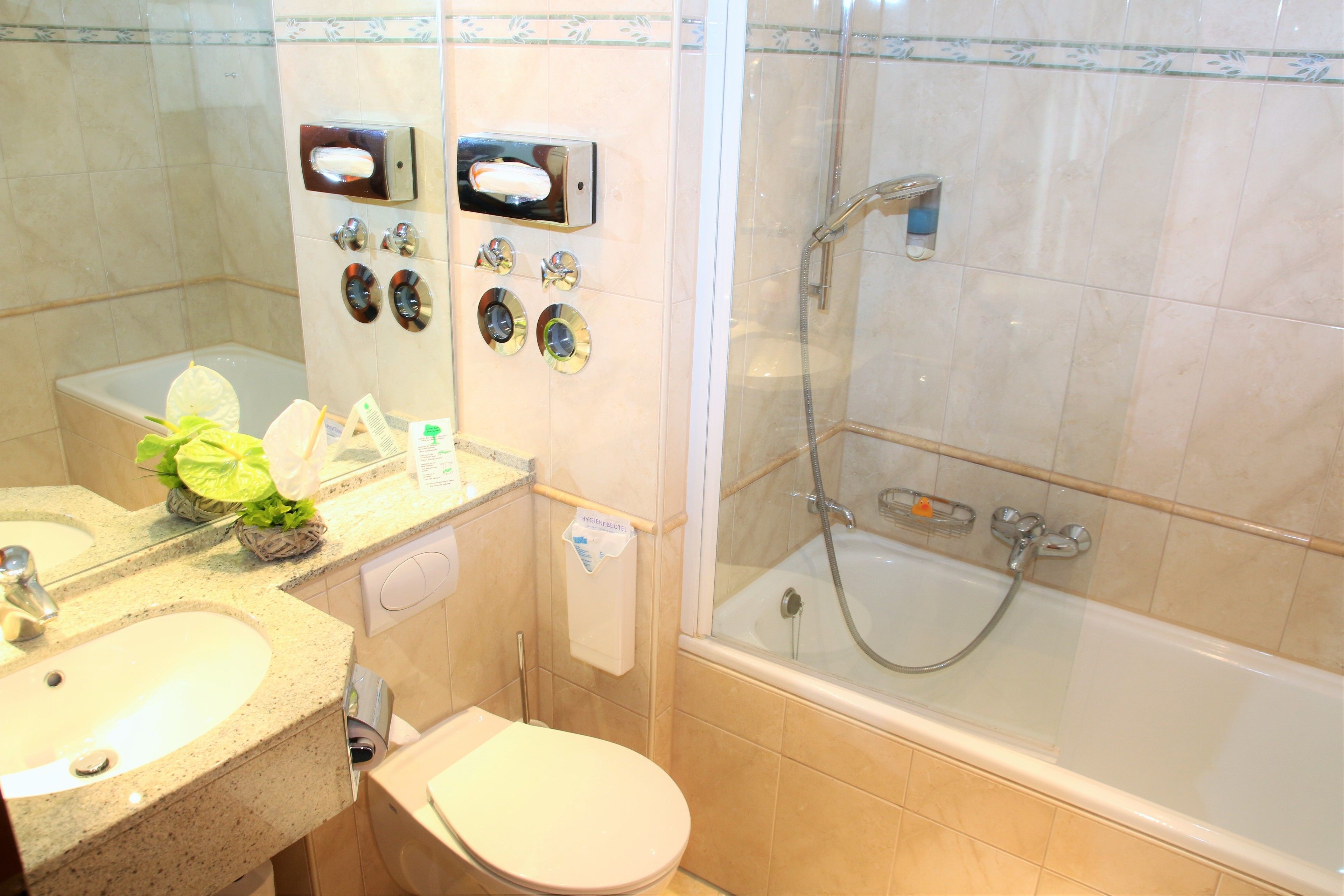 A bathroom with a sink, toilet, and a glass-enclosed shower area.