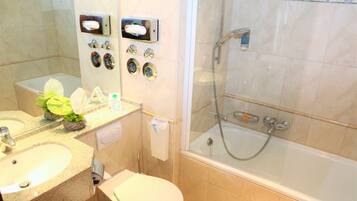 A bathroom with a sink, toilet, and a glass-enclosed shower area.