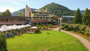A hotel with multiple floors, outdoor seating, and a garden area.