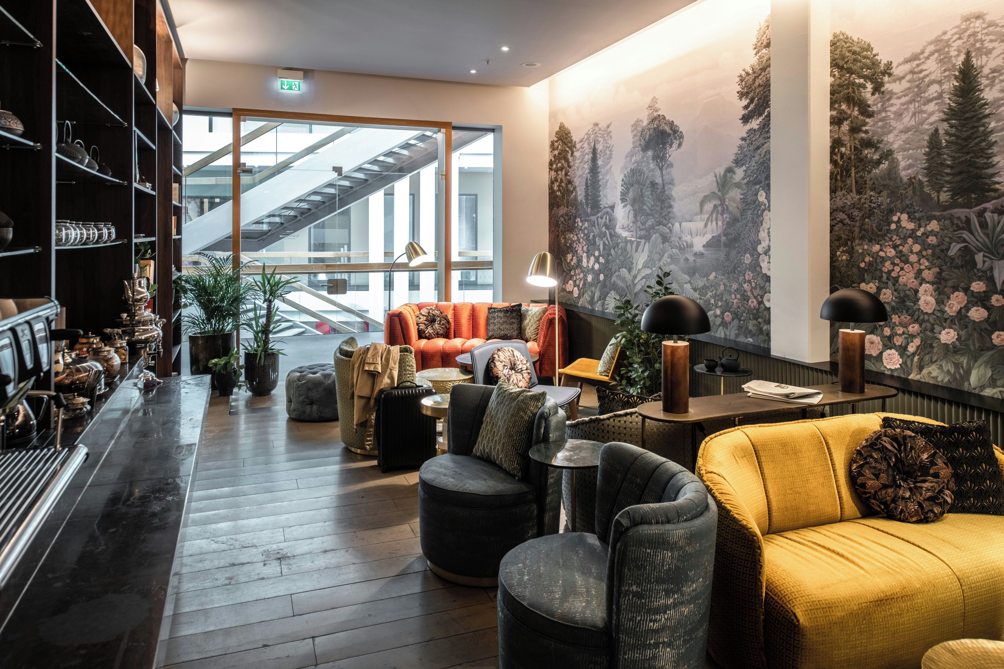 Ein stilvoller Lounge-Bereich mit Bar, Sitzgelegenheiten und einer großen Wandmalerei.