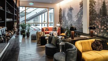 Ein stilvoller Lounge-Bereich mit Bar, Sitzgelegenheiten und einer großen Wandmalerei.