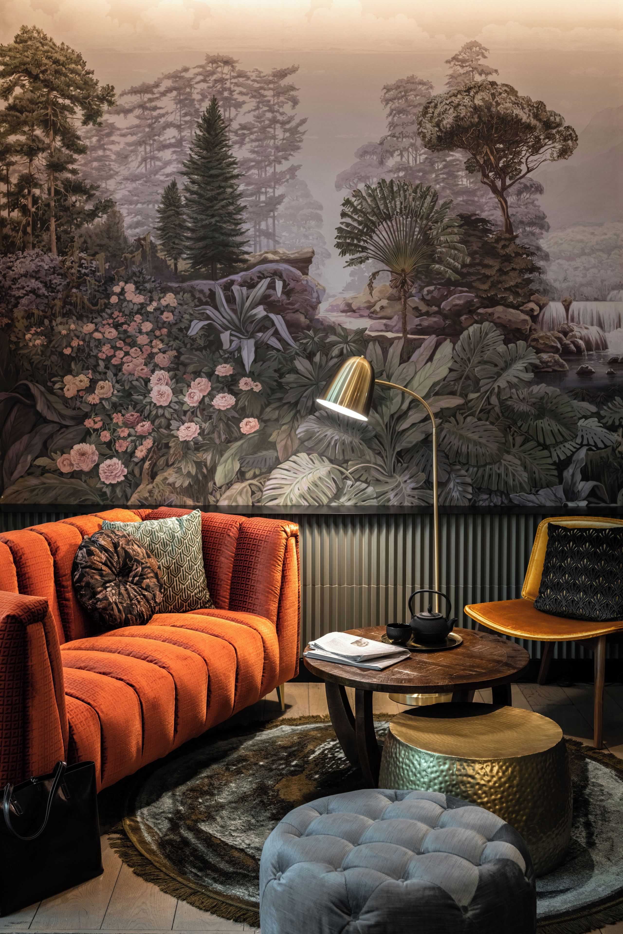 A room with a sofa, a coffee table, a chair, and a decorative lamp.