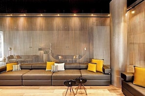 A modern living room with a sectional sofa, two small side tables, and a textured wall. - The Cloud One Dresden-Frauenkirche (Dresden)