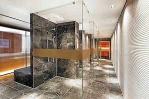 A modern bathroom with glass partitions, marble flooring, and recessed lighting. - The Cloud One Dresden-Frauenkirche (Dresden)