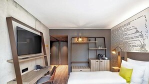 A modern hotel room with a large bed, a desk with a chair, a television, and a coffee machine. - The Cloud One Dresden-Frauenkirche (Dresden)