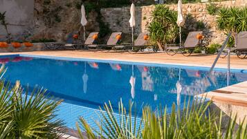 Alberca al aire libre por temporada y sombrillas en la alberca