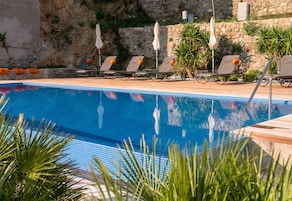 Una piscina al aire libre de temporada, sombrillas