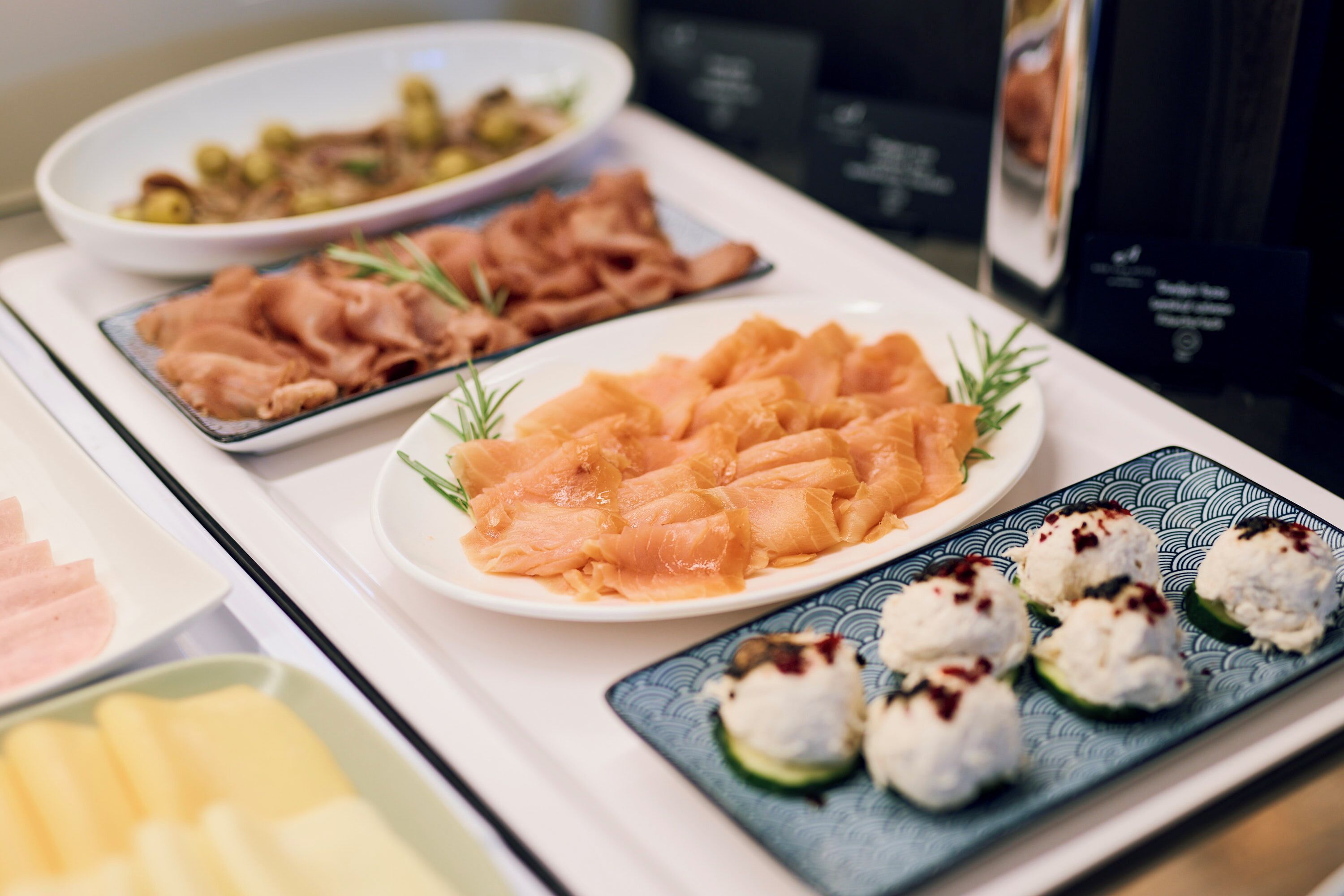 Un buffet proposant une variété de plats, notamment du saumon, des légumes et des sushis.