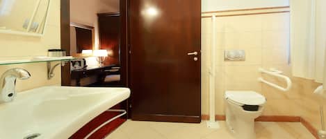 Une salle de bain équipée d’un lavabo, de toilettes et d’une douche.