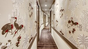 Un pasillo con papel tapiz estampado y piso alfombrado.