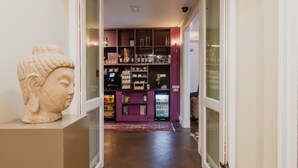 A hallway with a Buddha statue, a purple storage unit, and a refrigerator. - Hotel Roemer (Amsterdam)