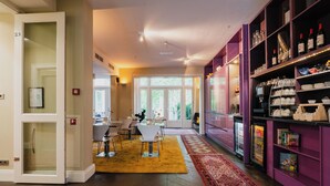 A modern interior with a dining area, a kitchen, and a storage area with shelves. - Hotel Roemer (Amsterdam)