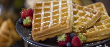 A plate of waffles with strawberries and blueberries.