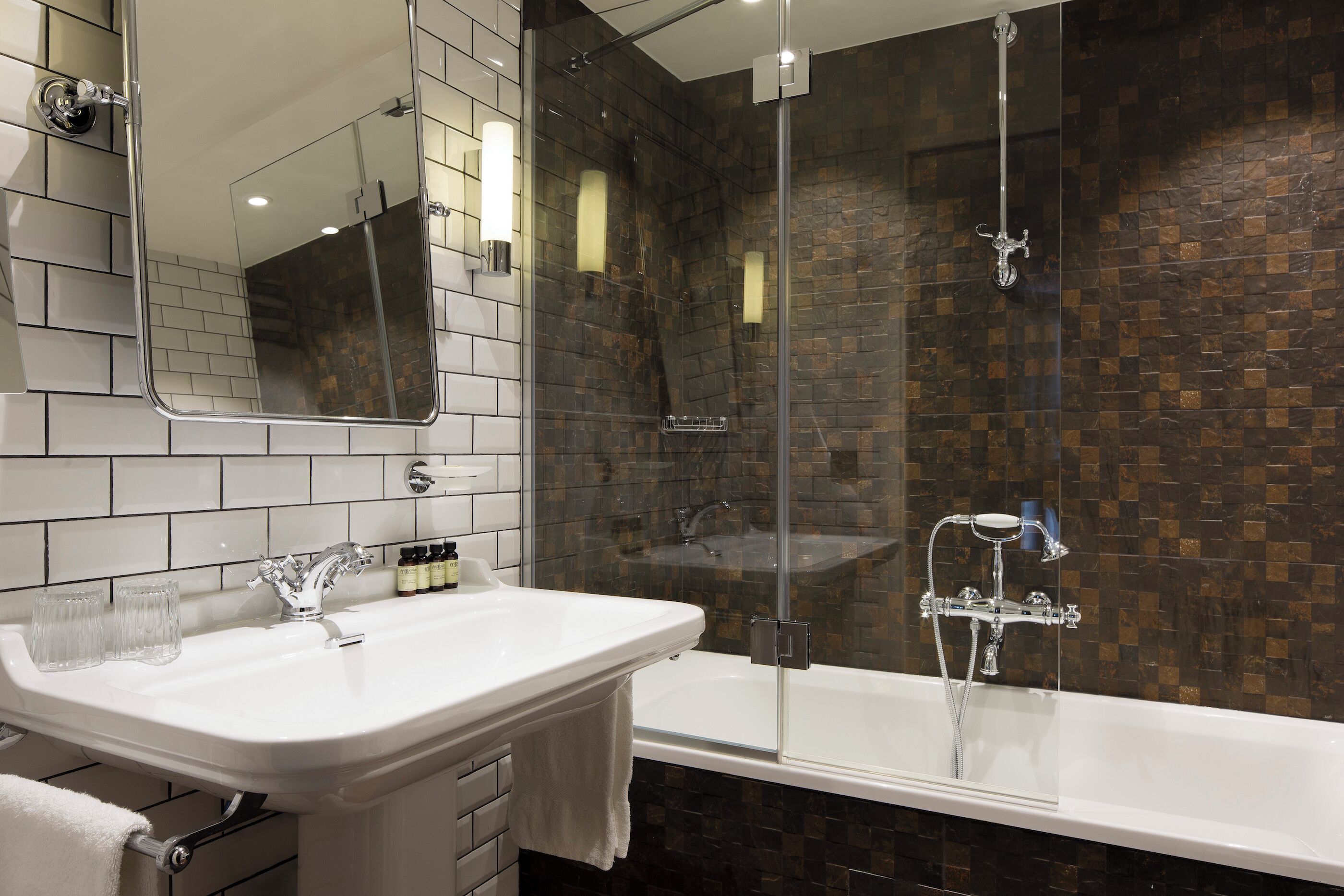 Une salle de bain moderne avec un lavabo blanc, une douche en verre et un grand miroir.