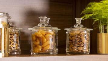 Three glass jars on a shelf containing different food items.
