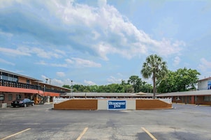 A motel with a sign reading "Rodeway Inn" in front of a parking lot.