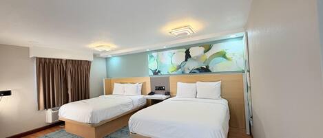 Une chambre d’hôtel avec deux lits, une grande peinture abstraite au mur et un design moderne au plafond.