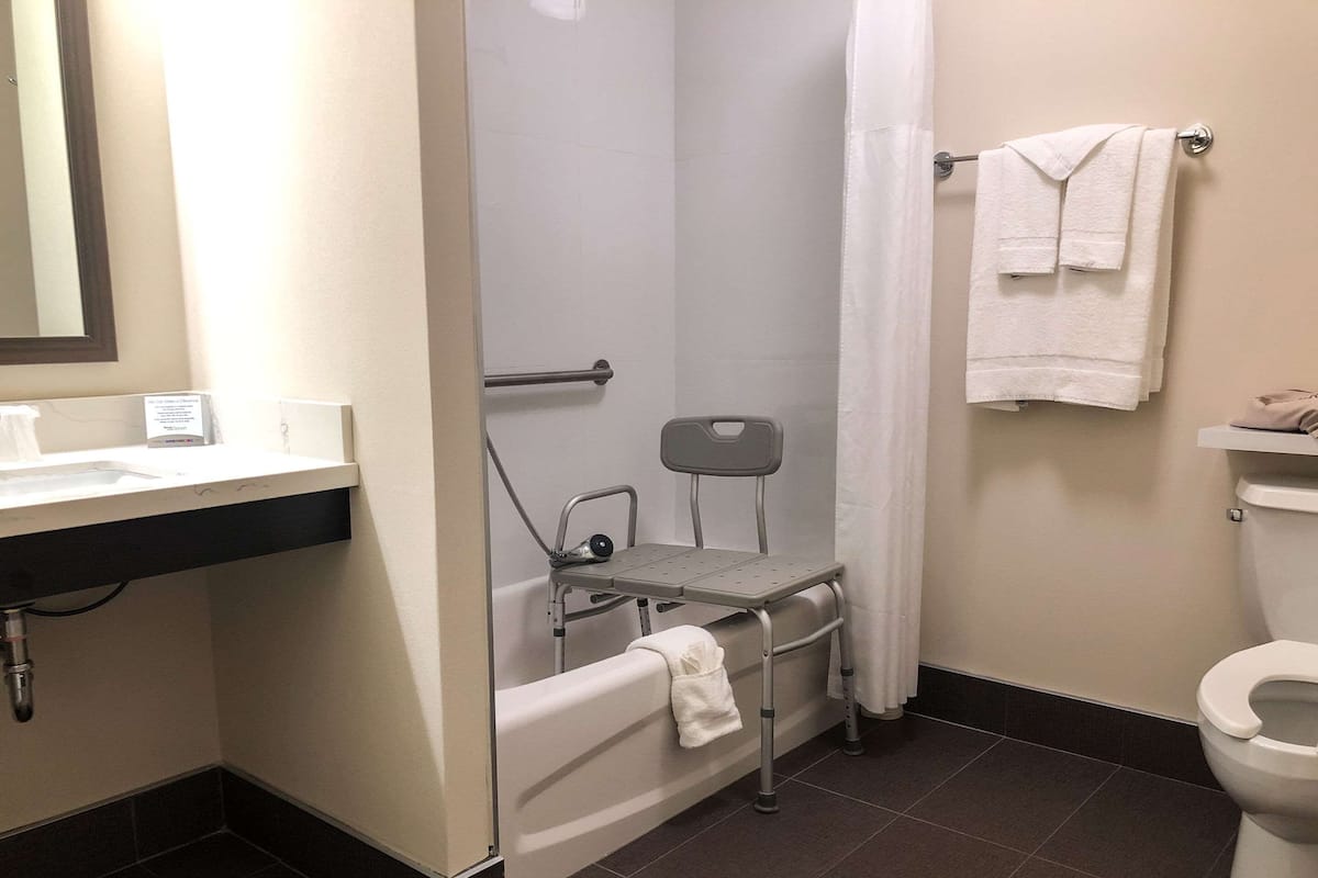 A bathroom with a shower, toilet, and sink.