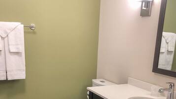 Un baño con lavamanos blanco, un espejo y un inodoro.