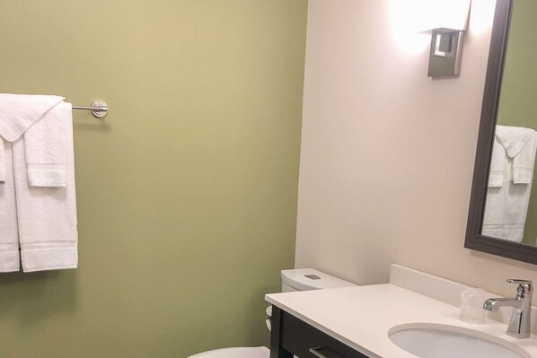Un baño con lavamanos blanco, un espejo y un inodoro.